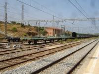 A lengthy rake of what appear to be redundant two axle covered car carrier wagons, with associated flat wagons, are stored in the sidings alongside Llanca Station between Portbou and Figueres. Above the flat wagons can be seen the traction power supply connection from the local Spanish electricity network to that section of line<br><br>[David Pesterfield 07/08/2015]