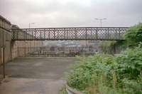 This footbridge linked the two portions of Bogle Street which were split by the construction of Greenock Central station, behind the large stone wall to the left. Straight ahead was the extensive goods yard. This photograph was taken during the reconstruction of Greenock Central in 1996, which largely consisted of the demolition of the remaining portion of the overall roof and the neighbouring station buildings. A much smaller station building was provided at the same time and the entry arches retained.<br><br>[Ewan Crawford //1996]