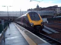 A CrossCountry Voyager, arriving from the south, rolls into the shelter of the Waverley canopies during a brief shower of rain. Traces of the shield affixed by the unit's previous operators, Virgin, can clearly be seen beneath the windscreen. The stock of the Borders Railway steam special can be seen over on the right, has also recently arrived from Tweedbank, and is about to be taken back out to Craigentinny [see image 52713].<br><br>[Andrew Wilson 24/09/2015]