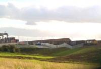 A rare view of the DIRFT 'super shunter' on 25 September 2015 [see image 52516] with a load in tow. That pile of containers on the left seems to be getting taller by the day.<br><br>[Ken Strachan 25/09/2015]