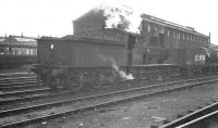 Shed pilot duties being undertaken at Stratford  by J15 0-6-0 65462 in October 1960, with neither locomotive nor shed looking at their best. The old steam shed and locomotive works at Stratford are long gone, though happily the veteran 0-6-0, a product of the nearby works in 1912, was purchased for preservation following withdrawal in September 1962. [See image 52880] <br><br>[K A Gray 09/10/1960]