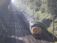 Its great that a number of Cumbrian Coast trains have gone over to Class 37 haulage but a lot of photographers wish the locos were at the southern end of the train with the DBSOs to the north. 37423 is backlit by the sun as it heads north from Preston with the daily service to Barrow in Furness. The train is just approaching Lightfoot Lane bridge, above the long cutting from Oxheys.    <br><br>[Mark Bartlett 01/10/2015]