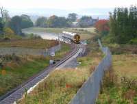 Still leftover traces of an early morning mist hanging over the countryside on 18 October 2015 as the 0945 Sunday service from Tweedbank crosses the A7 viaduct at Hardengreen and begins to slow for the Eskbank stop.<br><br>[John Furnevel 18/10/2015]