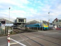 Progress at Port Talbot on 17 October 2015 with all main sections of the new footbridge now in place. Arriva Trains Wales 175104 is restarting the 0707 Milford Haven - Manchester Piccadilly over Oakwood Road level crossing. <br><br>[Alastair McLellan 17/10/2015]