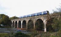 An Edinburgh - Glasgow Queen Street service passes crosses the M80 on 20th October 2015. In addition to the more obvious OHLE preparation and metal and stonework repairs, renovation work on the viaduct includes installing a series of stairs, walkways and platforms inside the structure and ground-level entry points for each span.<br><br>[Colin McDonald 20/10/2015]