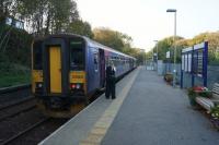 A Falmouth Docks to Truro service waits at the northern end of Penryn station on 12 October 2015 to pass the southbound service. The passing loop is on the left but the southbound service stops behind the photographer at the same platform. <br><br>[John McIntyre 12/10/2015]