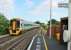 1588798 on a Warminster to Westbury service passes the southbound platform at Dilton Marsh, opened by the GWR in 1937. This view shows the full extent of the tiny halt and the northbound platform can just be seen beyond the rather superfluous <I>Way Out</I> sign. <br><br>[Mark Bartlett 25/07/2015]