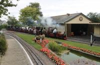 An outbound train on the Beer Heights Light Railway passes the Motive Power Depot. The substantial shed is actually one of three similar buildings alongside the line. The train will loop round at the bottom end of the site before running along the line in the foreground towards the tunnel and panoramic hill side beyond. <br><br>[Mark Bartlett 01/08/2015]