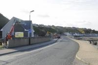 There is a new building on the site of Banff Station site. The station throat was located at the point marked by the yellow JCB at middle distance. The North Sea is to the immediate right of roadway. The line curved behind the row of cottages on the shoreline, on its way to Golf Club House halt and the junction with the Coast line at Tillynaught. The line closed to all traffic in 1968.<br><br>[Brian Taylor 20/10/2015]