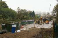 A view over the work site at the south end of Farnworth Tunnel on 31 October 2015. Since my last visit the TBM has completed it's task and much of the plant has been cleared although there are still several tasks to be completed before the track is laid. For the moment services continue to use the single line through the Down tunnel like the pair of Class 150s that are passing behind the sleeper screen.<br><br>[John McIntyre 31/10/2015]