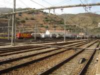 A lengthy loaded intermodal rake is being propelled into the SNCF/RENFE interchange yard alongside Portbou station by SNCF Fret Bo-Bo loco 469203 [See image 52995] Note the railway worker seated above the rear buffer of the leading wagon. <br><br>[David Pesterfield 07/08/2015]