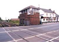 Looking south across Station Road level crossing towards Bedlington South signal box in May 2004. The long closed Bedlington station is behind the camera with an appropriately named hostelry located on the far right. The northern end of Furnaceway Sidings can be seen in the left background just beyond the crossover. [See image 49300]<br><br>[John Furnevel 25/05/2004]