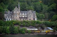 Loch Awe Hotel, perched above Loch Awe station, viewed across - you guessed it - Loch Awe. The former 'tea train', now accommodation, can be seen at the station site. The steamer pier was immediately off to the right. Breadalbane, who did so much to promote the railway, was also behind the development of this hotel. A (somewhat ugly) luggage lift formerly linked the station to the hotel.<br><br>[Ewan Crawford 10/06/2013]