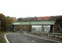 GBRf 66747, a former Eurospec Class 66 still in livery as imported, creeps east across the bridge over a former, once manic, dual carriageway section of the A1 trunk road that still runs by Ferrybridge up to the M62 motorway. The train is waiting for right of way onto the Knottingley line to reach Drax Power Station.  <br><br>[David Pesterfield 03/11/2015]
