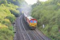 Class 59 59202 and stone empties for Whatley Quarry approaching Clink Road Junction on 25th July 2015. Although clearly working hard it is just about to diverge right onto the Frome loop [See image 52140] rather than take the <I>cut off</I> main line route towards Taunton. <br><br>[Mark Bartlett 25/07/2015]