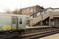 The street level 1930s <I>art deco</I> booking office at Moreton, and the associated concrete footbridge, are seen to good effect as EMU 508110 pulls away on a Wirral Line service heading for West Kirby in November 2015.<br><br>[Mark Bartlett 16/11/2015]
