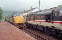 37s crossing at Taynuilt in 1989. The view looks east to Ben Cruachan with the now removed station building behind the locomotives 37403 (Oban bound) and 37409 'Loch Awe' (on the eastbound 'The West Highlander'). Sprinters had been introduced but this Oban service was 37 hauled.<br><br>[Ewan Crawford //1989]