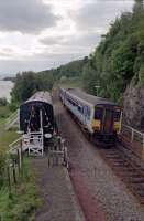 The carriage at Loch Awe which was home to Harry Watson (who is seen here to the left watching the passing train). This carriage is on a section of track installed by slewing the line over and then replacing the slewed section. The carriage later became the 'tea train' and now provides accommodation.<br><br>[Ewan Crawford //1991]