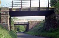 Just east of Midcalder Junction a short branch ran off the Shotts line (distant bridge) to Oakbank Oil Works (nearer bridge). The branch had its own signalbox, Oakbank. [See image 51104]. This view looks south in 1990. The bridge still stands today.<br><br>[Ewan Crawford //1990]