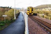 158705 leaves Tweedbank and crosses the River Tweed on Redbridge Viaduct with a train for Edinburgh on 4 December 2015. The walkway of the Southern Upland Way shares the viaduct. [See image 38163] <br><br>[Malcolm Chattwood 04/12/2015]