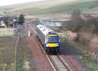 The 1225 Edinburgh Waverley - Tweedbank southbound through the site of Heriot station on 19 December 2015. The station building and platforms have gone, along with the old level crossing, now replaced with an underpass linking the village (off to the left) and the bus stop alongside the A7.<br><br>[John Furnevel 19/12/2015]