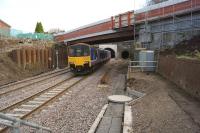 A Blackpool North service leaving the new Farnworth Tunnel on 23 December 2015. The train is passing under the new Cemetery Road bridge and approaching the repositioned Farnworth station. To the right is a section of the old platform, with the former down tunnel in the background.<br><br>[John McIntyre 23/12/2015]