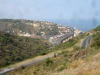 A long distance panoramic view east over Cerbere from within Spain, with a lengthy intermodal rake seen alongside the station, and rakes of carriages stabled in the transhipment yard. Two SNCF electric locos and an SNCF Fret 469200 series Bo-Bo diesel shunting loco are stabled between station and yard, with the nose of a further electric loco, on the southern end of the intermodal rake, just visible below the signal gantry.   <br><br>[David Pesterfield 07/08/2015]