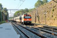 A stopping train for Barcelona leaves the wayside station at St Miquel de Fluvia passing through the long sandstone cutting. This station is just south of Figueres on the main line that comes down the Catalan coast from the Franco-Spanish border. <br><br>[Mark Bartlett 21/09/2015]