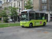 One of the electric midi buses operating a free shuttle service, Sundays excepted, around the centre of Reims, between the station and the Cathedral. The bus is crossing the tracks of the Reims tramway by the south end of Langlet tram stop.<br><br>[David Pesterfield 24/07/2015]