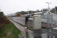 Nothing holds back our intrepid photographers. Come rain (quite a bit of rain), shine or high fences. [See image 49879] for a view of John taking the same step exactly one year previously.<br><br>[Ewan Crawford 26/12/2015]