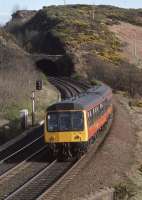 107 729 coasts downhill from Ferryhills Tunnel (also known as North Queensferry Tunnel) with an Edinburgh - Fife local in April 1990. The hybrid tunnel/cutting is visible in the background. [See image 53562].<br><br>[Bill Roberton /04/1990]