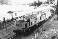 6851+6850 with a tank train at Bishopbriggs oil terminal on a sunny evening in 1971. On the left is the E&G main line, where 5406 is passing with a westbound freight. 6851 is notable for having hauled the last down Anglo-Scottish freight over the Waverley Route (the 08.30 Kingmoor-Millerhill) on Saturday 4th January 1969. Delivered new from the Vulcan Foundry to Cardiff Canton in July 1963 it was later renumbered 37667 and eventually became part of the DRS fleet. [See image 51804]<br><br>[John Furnevel 17/08/1971]