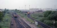 View west towards Bishopbriggs Oil Depot in 1987. The depot remained open until around 1990. 37085 and an unknown 37 are passed by a 477 propelling towards Glasgow.<br><br>[Ewan Crawford 27/05/1987]