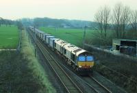 The Daventry to Mossend <I>Tesco Express</I> was a few minutes early at Woodacre on 4th January 2016 but the train faced a lengthy detour via Dumfries, Mauchline and Prestwick due to the Lamington bridge closure. DRS 66303 and 66302 double-head the long train through the open countryside between Preston and Lancaster. <br><br>[Mark Bartlett 04/01/2016]