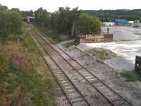 View from Bretton Street overbridge looking along what was latterly the Railway Street branch towards Headfield Junction. The Market Place line continued ahead through the stone arch and the line to Railway Street goods yard turned off to the right under the steel bridge to cross both Mill Street East and the River Calder en route. Not aware if stone is still being delivered periodically to the yard on the right, although it looks probable. [See image 53805] for a view in the opposite direction. <br><br>[David Pesterfield 03/09/2015]