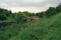 A 1997 view east along a very old trackbed. This is the Niddrie to Fisherrow alignment which was severed by the North British's 1847 Portobello to Niddrie South Junction line.<br><br>
<br><br>
Off to the left is the 1884 line from Niddrie West Junction which opened in connection with the Edinburgh, Suburban and Southside Junction Railway. This connected to the ECML at Niddrie East Junction and used a portion of the old Fisherrow branch, the junction with the ECML was moved further south with the opening of the Lothian Lines. This alignment closed in 1983.<br><br>
<br><br>
Further to the left, and built to coincide with the severing, the Fisherrow Branch was connected to the Portobello to Niddrie line by a 1847 north to east curve which met the Portobello line at Niddrie junction [2nd] where there was an interchange station ('Niddry Junction'). Thus a NB train heading for Fisherrow would turn south at Portobello, east at Niddrie Junction [2nd], pass over the NBR mainline before reaching Fisherrow. The line probably fell into abeyance when the new 1859 curve from Newhailes Junction to the Fisherrow/Musselburgh Branch opened. A portion - as above - was to re-open in 1884.<br><br>
<br><br>
This site and the three lines here have since been redeveloped.<br><br>[Ewan Crawford //1997]