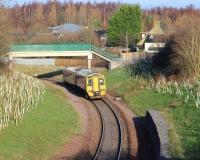 An Edinburgh bound DMU on the Borders Railway heads north from Newtongrange on 11 January 2015. The train is about to pass below the second of the two new pedestrian footbridges built here, as it turns left towards Newbattle Viaduct. <br><br>[John Furnevel 11/01/2015]