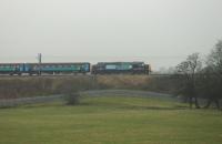 DRS 37409 <I>Lord Hinton</I> propels the Northern 0515 Carlisle to Preston southwards on 19th January 2016. The train is on the embankment immediately south of the closed station at Bay Horse. <br><br>[Mark Bartlett 19/01/2016]
