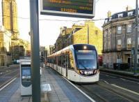 An airport- bound Tram pulls into West End - Princes Street tram stop on 28 January 2016. This stop was originally to be called Shandwick Place; less ambiguous and in fact where the stop is. The gable in the background is on Canning Street, from the days when streets were named after prime ministers even if they'd only been in office for 4 months.<br><br>[David Panton 28/01/2016]