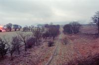 View south at Loch Leven with sleepers still at the site of the shed to the left and, further left, the approach to the goods yard. Briefly, in 1860, this was the Kinross terminus of the line from Lumphinnans before the Fife and Kinross was extended south from Hopefield and this line extended north to meet it at a new through station (Kinross [3rd], renamed Loch Leven in 1871 and closed in 1921). The Hopefield station became Kinross Junction station on the opening of the Devon Valley line, was rebuilt on the opening of the Forth Bridge and survived until 1970.<br><br>
<br><br>
The North British provided a Loch Leven curlers' platform south of here.<br><br>
<br><br>
Loch Leven itself is visible to the left.<br><br>[Ewan Crawford //1996]