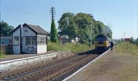 A 47 enters Nairn with an Inverness train in 1990. The signalman waits to take the token and to the left, by the east box, is his bicycle to take him to the west box. The bicycle wasn't always used - the very next day it wasn't. A puncture perhaps!<br><br>[Ewan Crawford //1990]