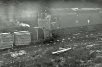 The unusual sight of a narrow gauge locomotive (No.7) pulling in to the yard at Gathurst alongside Class 25 25105 in 1978. The narrow gauge trucks are loaded with explosives, which will be transferred to <I>gunpowder vans</I> dropped off by the Type 2 from the pick up freight from Southport in Gathurst yard. Footnote: Apologies for the fogging on this picture but it does capture a long gone scene that wasn't widely photographed. [See image 21338]<br><br>[Mark Bartlett 28/11/1978]