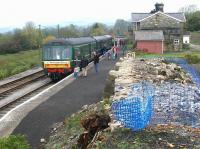 A Wensleydale Railway DMU for Leeming awaits its departure time at Redmire on 30 October 2004. View is west towards Hawes, looking over the partially demolished coal drops.<br><br>[John Furnevel 30/10/2004]