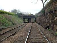 View looking west (Down) with OB17 Craigmillar Park/Mayfield Gardens (A701) in the background and former Newington Station beyond. Here the both lines are jointed rail on concrete sleepers. Look carefully at the base of OB17 to see the safety Lookout (orange blob) just visible to the left of the Down line. For another view of this bridge [see image 54972]; same bridge, different bus.<br><br>[Charlie Niven 25/04/2002]