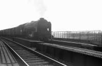 The bridge carrying the Waverley route over the WCML at the south end of Kingmoor yard in May 1964. The train crossing the bridge is the late afternoon 4.33pm Carlisle – Millerhill and the locomotive is A1 Pacific no 60152 <I>Holyrood</I>, working home to St Margarets shed.<br><br>[K A Gray 23/05/1964]