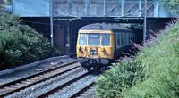 Midway between Bearsden and Westerton 311097 passes under Canniesburn Road on its traditional route to Springburn.<br><br>[Ewan Crawford //1988]