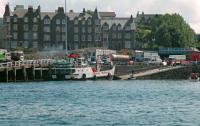 Island Class MV Eigg loading at the slip by Oban station (note the signalbox on the right by the Albany Street overbridge) before heading for Lismore on a run which this ferry operated for many years. Vessels in this class were not much more than landing craft. Eigg is now Caledonian MacBrayne's oldest vessel, dating from 1974.<br><br>[Ewan Crawford //1988]