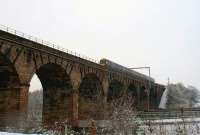 On a cold February afternoon, an Edinburgh - Glasgow  DMU crosses the M80 unaffected by the snow which has slowed motorway traffic.<br>
One set of OHLE masts has been fitted to its support brackets on the viaduct [see image 52829]. <br><br>[Colin McDonald 13/02/2016]