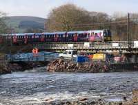 The 0725 First TransPennine Manchester Airport - Edinburgh Waverley passes slowly over Lamington Viaduct on the morning of 22 February 2016. The viaduct has reopened after extensive repair work following major structural damage caused by storm <I>Frank</I> at the beginning of January. The Network Rail staff are standing on the specially constructed secondary bridge which enabled plant and equipment to be moved to areas requiring attention. [See image 53760]<br><br>[John Furnevel 22/02/2016]