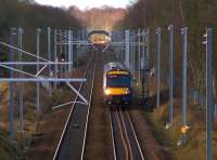 EGIP progress: 170432 on the 11:17 service from Glasgow Queen Street to Edinburgh speeds through the recently planted avenue of OHLE masts east of Lenzie whose station footbridge can be seen in the background.<br><br>[Colin McDonald 22/02/2016]